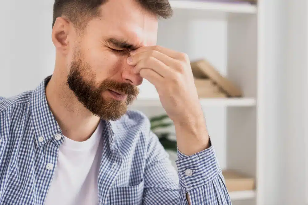 גבר עם עיניים אדומות ועצומות מכאב