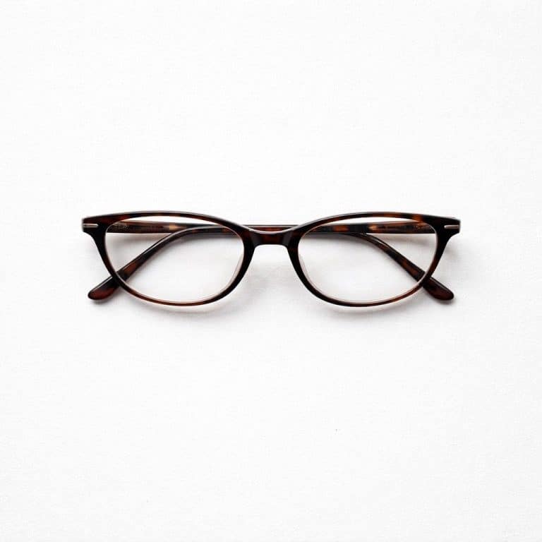 משקפיים חומים ועגולים עם מסגרת כהה, מונחים על רקע לבן חלק.