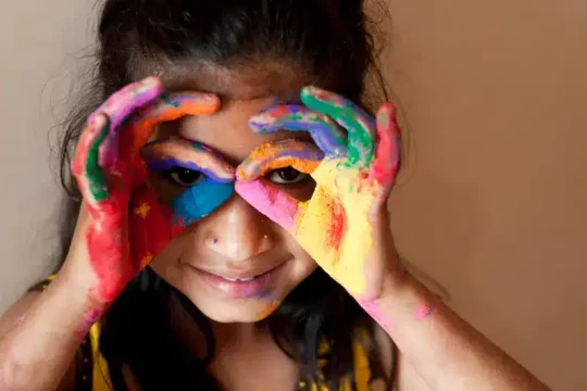 Kid with color on her hands